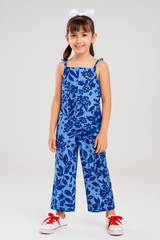 Young girl wearing a blue floral jumpsuit on a white background